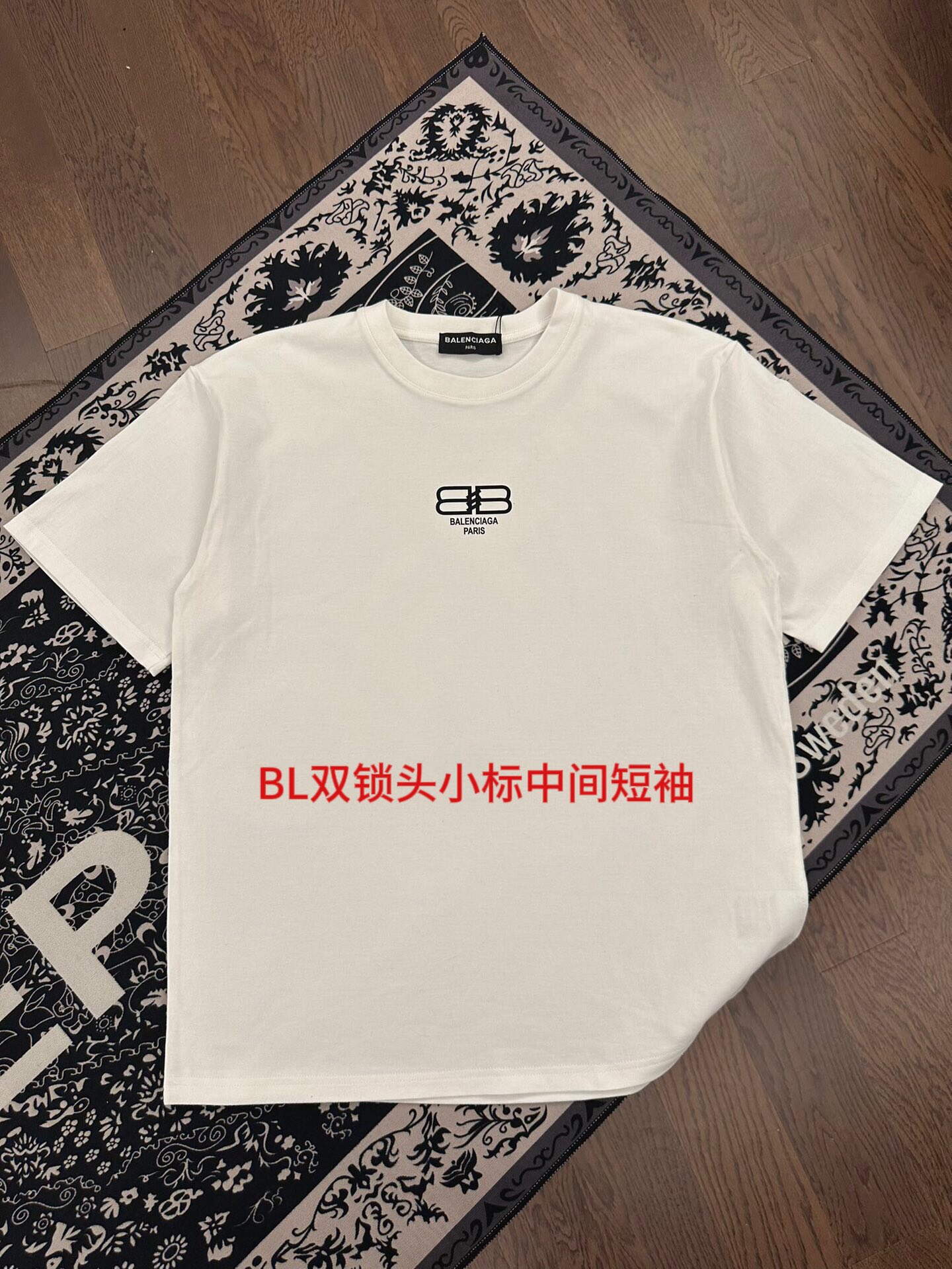 BL双锁头小标中间短袖沙中尺码：M-4xl颜色：黑色 白色    近两年oversize版型成了潮流的专注，也一直是近两年火爆主打，设计师的变更让此品牌一炮而红，时代的进步时装也需要新鲜的元素和新潮设计的血液冲击，才能把辉煌延续下去！内搭外穿都巨时髦，高街出行必备！绝对的“吸睛款”可搭配情侣